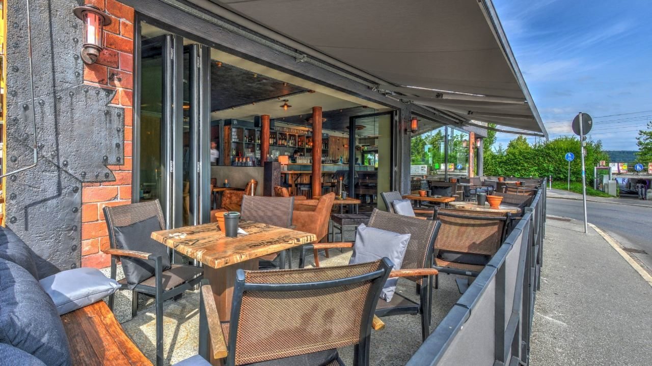 Terrasse mit gedeckten Tischen unter der Markise
